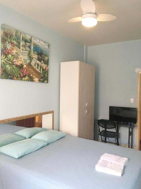 Foto mostrando cama, quadro, armário, tv, cadeira